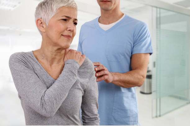 donna matura che soffre di mal di schiena durante l'esame medico. chiropratica, osteopatia, fisioterapia. medicina alternativa, concetto di sollievo dal dolore. - male doctor foto e immagini stock