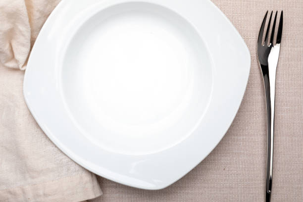 istock Empty white plate. On delicate beige tablecloth. Concept to include your food and your text. 1126492578