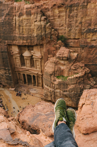 Scenic view  of  men's legs on the background of  Al-Khazneh in Petra from above