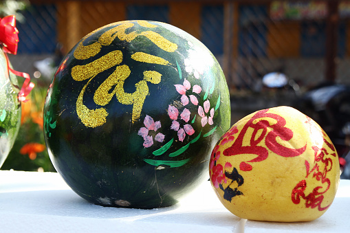 Watermelon and grapefruit decorated for celebration of Vietnamese New Year on a market in Hoi An, Vietnam. The inscription is translated  - Prosperity to you, Fortune.