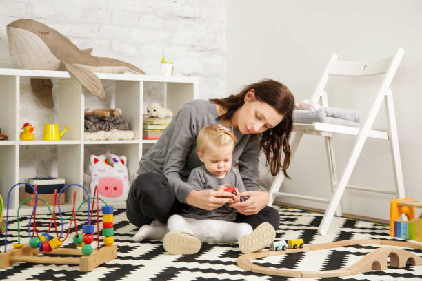 mutter und ihr baby girl zeit miteinander zu verbringen, in das kinderzimmer - babysitter stock-fotos und bilder