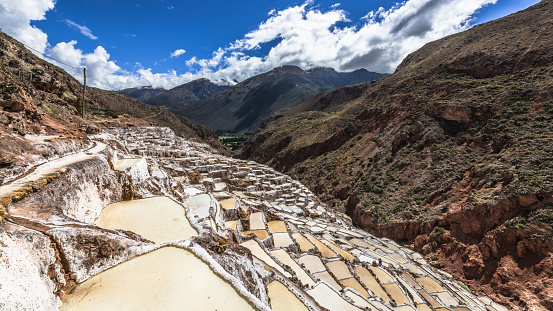 The white terraces of Salinas de Maras salt mines are located on the steep slopes of the Andes mountains.