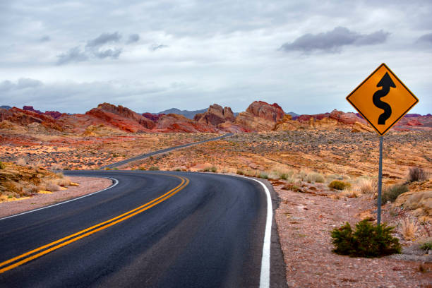 レッド ロック キャニオン道路標識と嵐の後の空の砂漠の道 - desert road road highway california ストックフォトと画像