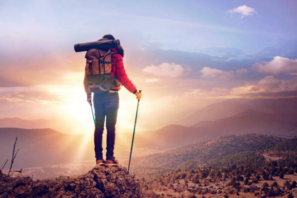 istock Young man backpacker hiking at seaside mountain cliff. The sun is rising. 1126507924