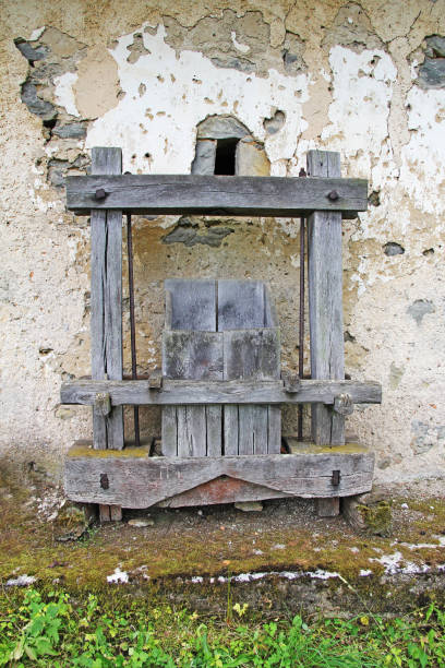 istock Old Antique wooden wine press in front of the rusty wall 1126510175