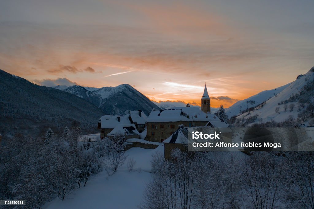 Unha sunset covered by snow Sunset over a mountain village at winter Beauty In Nature Stock Photo