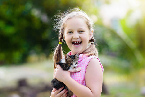 istock Little girl holding baby cat. Kids and pets 1126511708