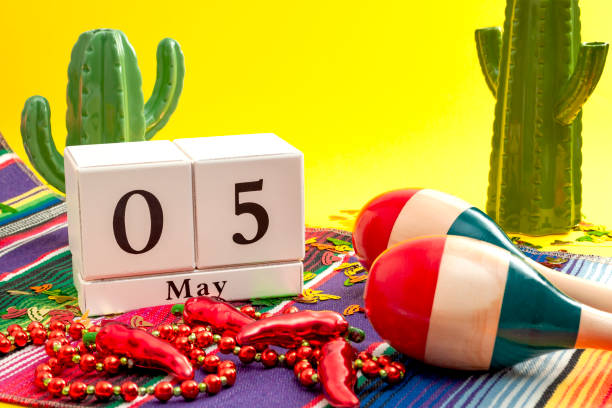 tema concept festa messicana fiesta e cinco de mayo con calendario il 5 maggio, collana di pepe jalapeno rosso, maracas, cactus, tappeto tradizionale e coriandoli a forma di sombrero su sfondo giallo - photography north america cactus plant foto e immagini stock