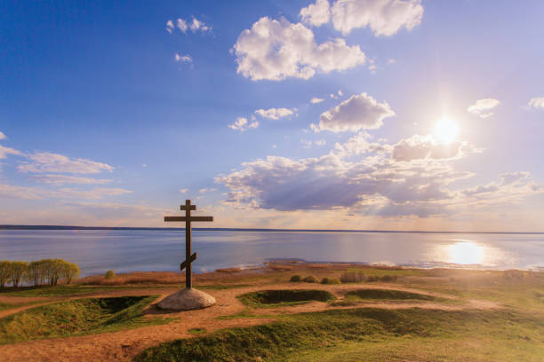 croce ortodossa al sole sullo sfondo del lago al tramonto - plescheevo foto e immagini stock