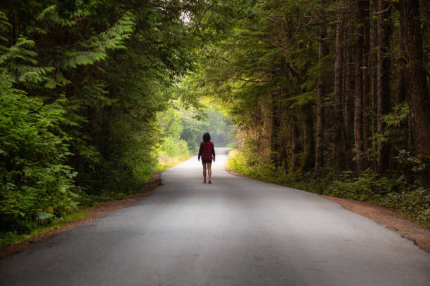 istock Girl walking on a scenic road 1126514983