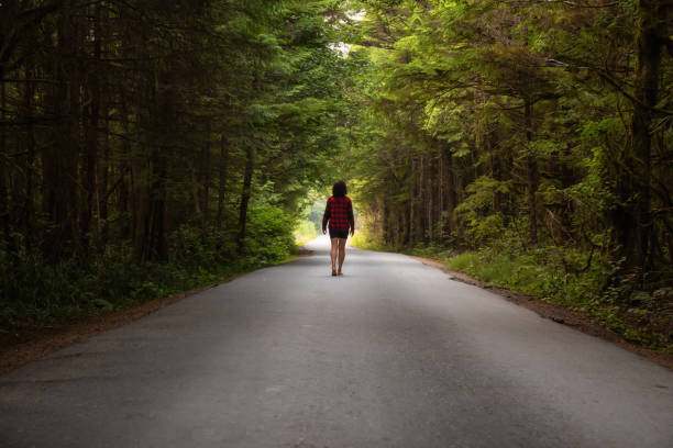 istock Girl walking on a scenic road 1126514991