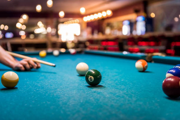 istock Hand with cue aiming on billiard ball at table 1126518580
