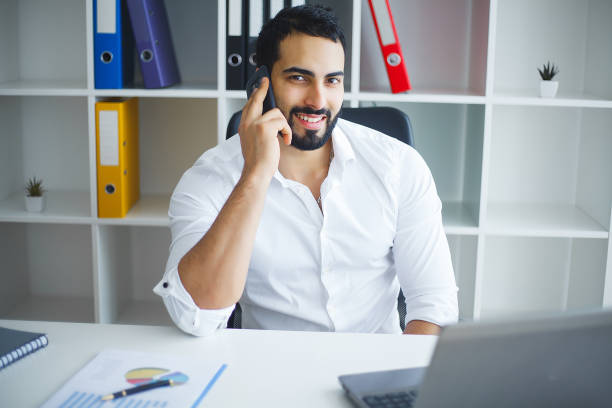 istock Smiling businessman using laptop at desk in office 1126519685