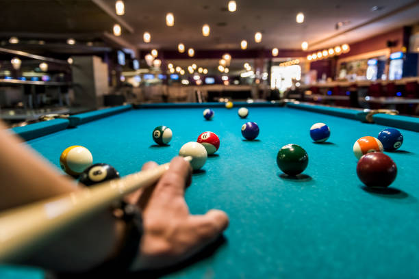 Hand with cue aiming on billiard ball at table Hand with cue aiming on billiard ball at table pool break stock pictures, royalty-free photos & images