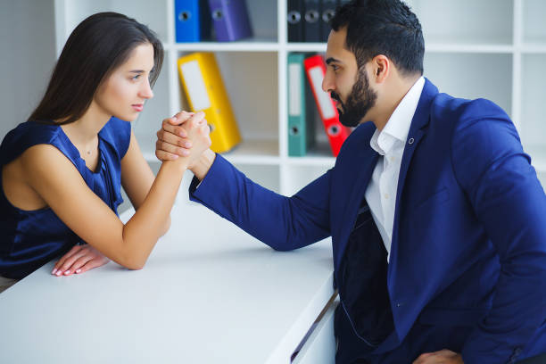 istock Man and woman doing arm wrestling in office 1126522747