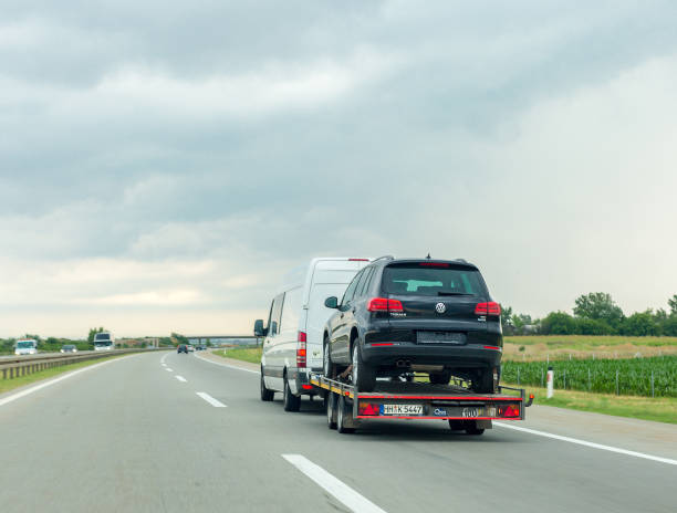 Car carrier trailer with new car on highway Nyiregyhaza, Hungary – September 06, 2018: Car carrier trailer with new car on highway bus hungary stock pictures, royalty-free photos & images