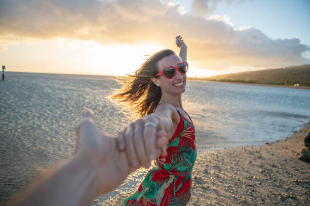 istock Lovers enjoying beach at sunset holding hands 1126525972