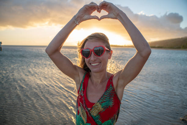 istock I love you, girl making heart shape finger frame on beach 1126528551