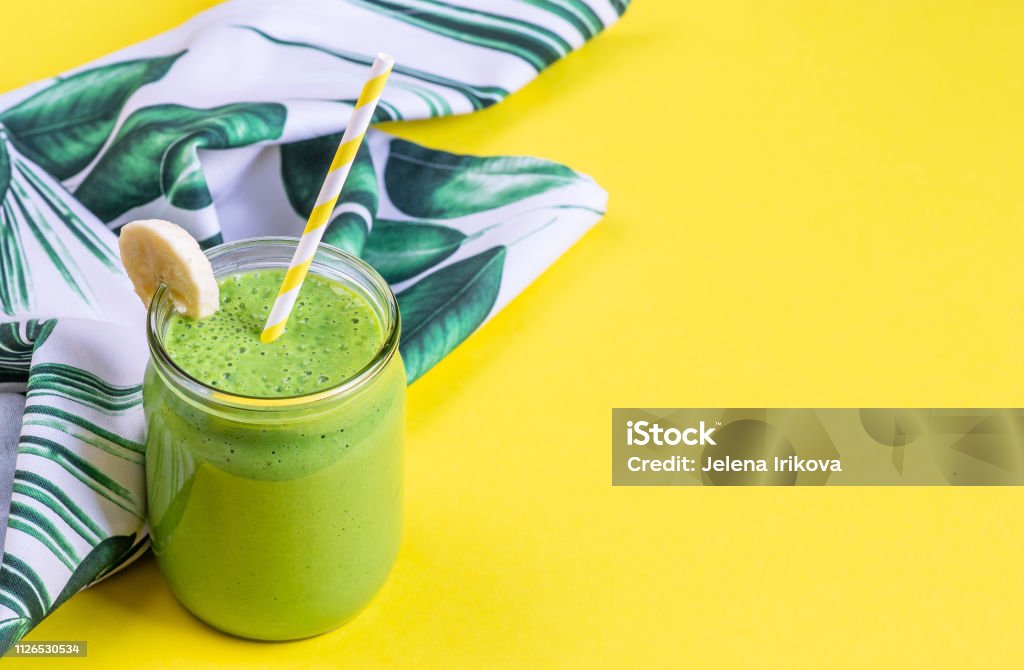 Green spinach smoothies in jar with chia seeds, healthy food concept, breakfast, yellow background Smoothie Stock Photo