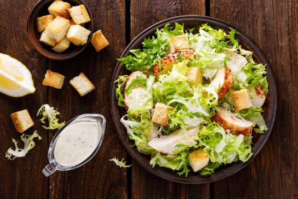 sezar salata izgara tavuk eti, taze marul, parmesan peyniri ve kızarmış kruton. klasik kuzey amerikan mutfağı. üstten görünüm - kruton stok fotoğraflar ve resimler