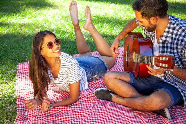 istock Happy couple playing guitar outdoors 1126538773