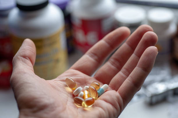 istock Man's hand with a bunch of pills 1126542268