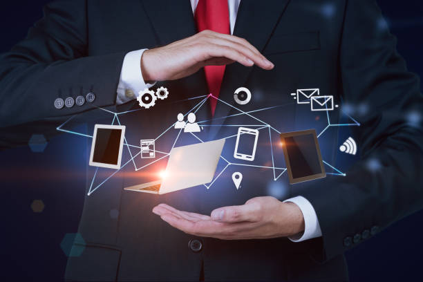 istock Man in red tie holding internet gadgets 1126544841