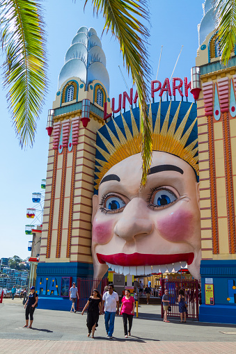 Sydney, Australia - January 23, 2019: Tourists walking in Sydney on back the main gate of Luna Park theme park.