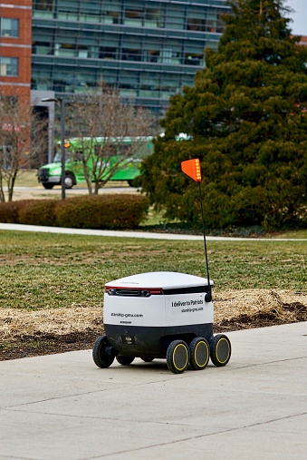 Fairfax, Virginia, USA - January 29, 2019: Close-up view of a newly operational delivery robot enroute to customers on George Mason University's main campus. The autonomous robots are operated by Starship Technologies and use artificial intelligence technologies to securely deliver food, drinks, and snacks to users anywhere on campus via a mobile app.