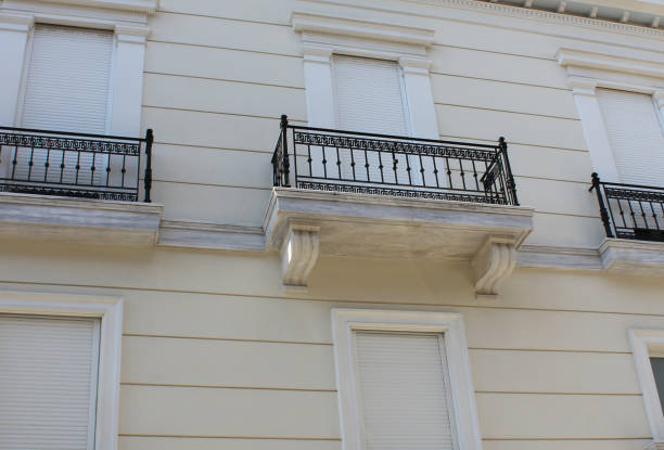 Disrespectful architectural intervention: Aluminium shutters on old neoclassical Athenian building stock photo