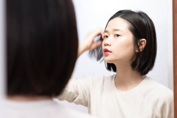 istock asian female looking in mirror 1126562556