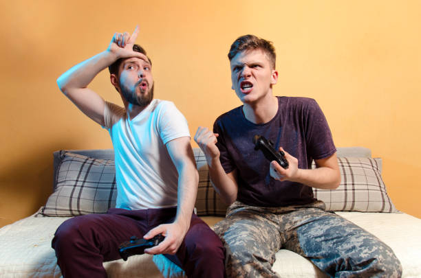 istock Older brother teasing young brother with L hand sign 1126563176