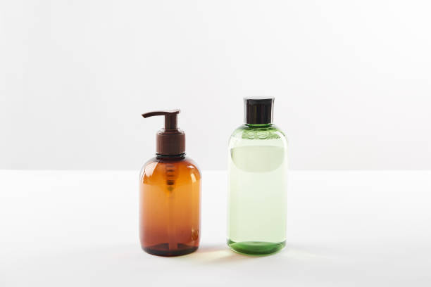 istock Cosmetic dispenser with lotion and bottle of serum on white surface 1126565329