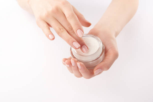 istock Partial view of woman applying hand cream on white background 1126565372