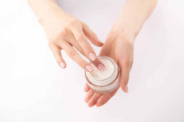 istock Partial view of woman applying hand cream on white background 1126565391