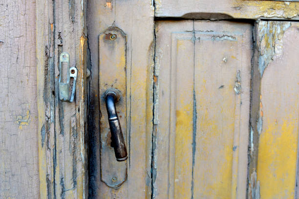 gałka drzwiowa na splądrowanych drewnianych drzwiach - pilled zdjęcia i obrazy z banku zdjęć