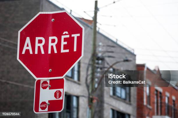 Quebec Stop Sign Obeying By Bilingual Rules Of The Province Imposing The Use Of French Language On Roadsigns Thus Translated Stop Into Arret Taken In The Streets Of Montreal Canada Stock Photo - Download Image Now