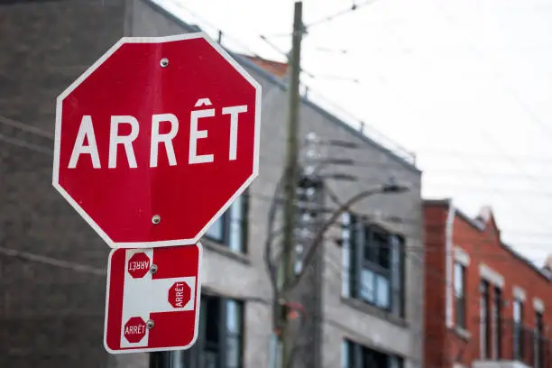 Picture of a Quebec stop sign, translated in French, called according to Quebec French speaking regulations panneau d'arret
