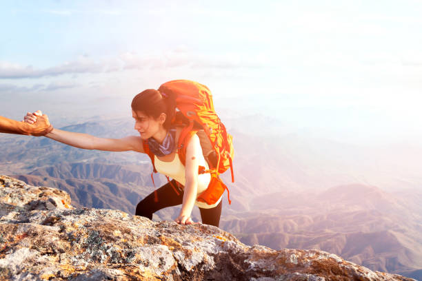 istock Teamwork couple helping hand trust in inspiring mountains 1126570601