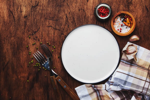 istock Empty plate with forks, napkin and spices on vintage wooden kitchen table 1126572127
