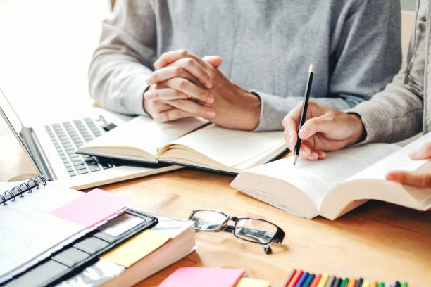 istock High school or college students studying and reading together in library 1126576090