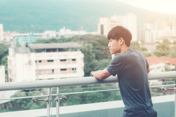 istock Lonely men are looking city view and sunset 1126576374
