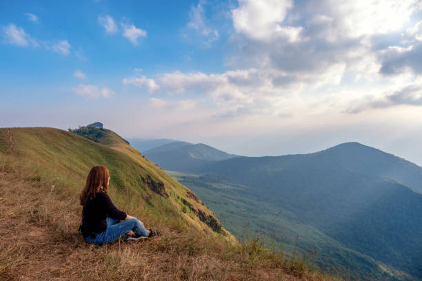 istock A woman sitting and watching sunset with mountains view 1126578948