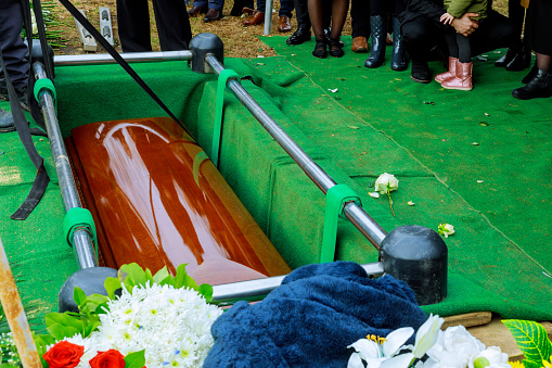 People at funeral putting down the coffin at a funeral