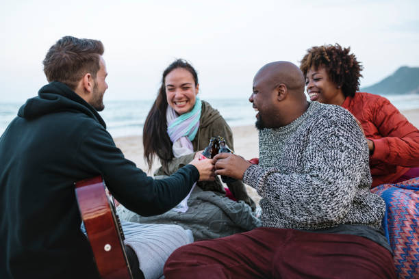 istock Diverse friends drinking beers at the beach 1126582017