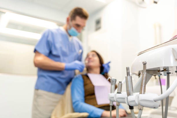 istock Dentist performing teeth treatment with female patient blurred, focus on tools 1126584193