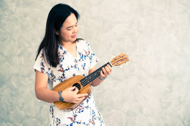 istock Happy woman musician playing ukulele 1126584287