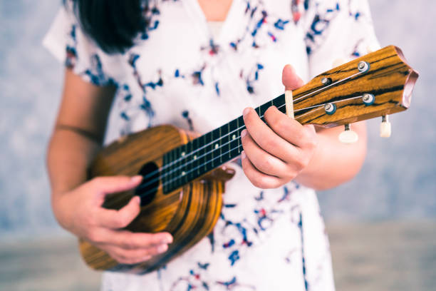 istock Happy woman musician playing ukulele 1126584303