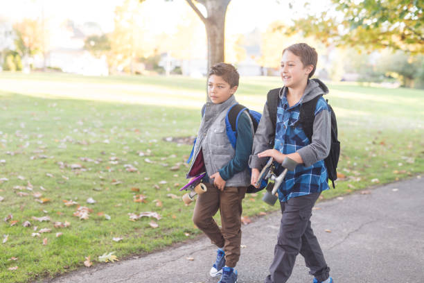 istock Two elementary-age boys walk to school through the park 1126588845