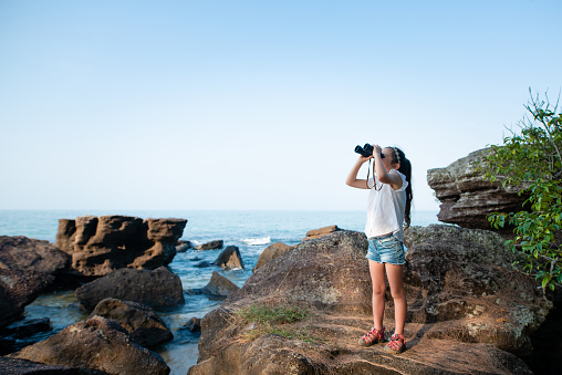 Girl using binoculars in the sea